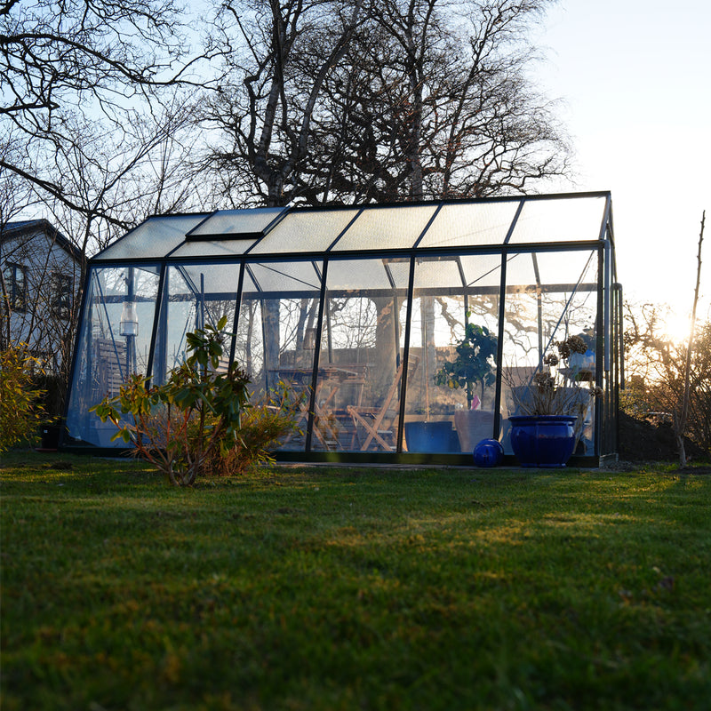 Vaxthusbolaget_vaxthus_S106 i solnedgång på gräsmatta i trädgård