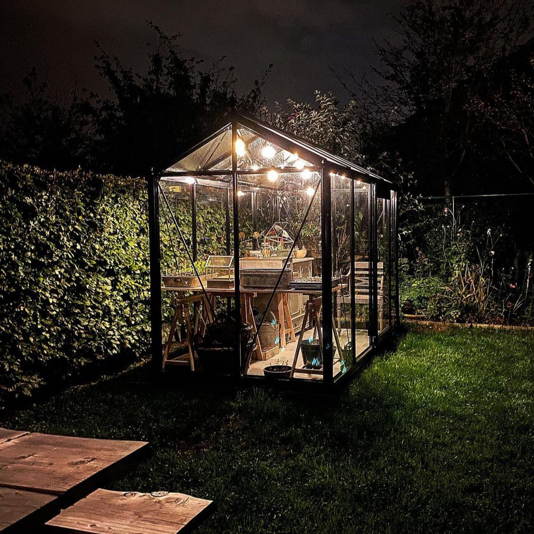 Nattbhild på växthusbolagets växthus Piccolo_5, med lampor i taket som lyser upp